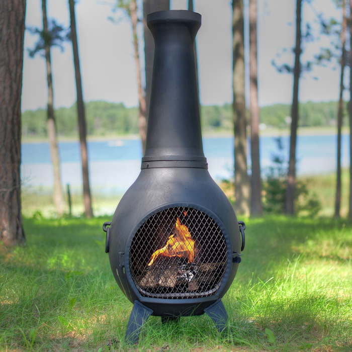 An outdoor chimnea with a wood fire burning